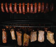 gerookt traditioneel gerookt vlees. een samenstelling van gerookt verkoudheid bezuinigingen Aan een zwart achtergrond. foto