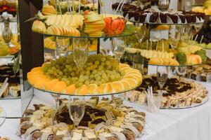 desserts met fruit, mousse, koekjes. verschillend types van zoet gebakjes, klein kleurrijk zoet taarten, macarons, en andere desserts in de zoet buffet. snoep bar voor verjaardag foto