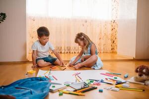 kinderen tekening Aan verdieping Aan papier. peuter- jongen en meisje Speel Aan verdieping met leerzaam speelgoed - blokken, trein, spoorweg, vlak. speelgoed voor peuter- en kleuterschool. kinderen Bij huis of kinderopvang foto