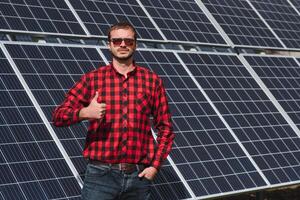 zonne- panelen. Mens staand in de buurt zonne- panelen foto