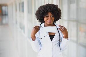 detailopname hoofdschot portret van vriendelijk, glimlachen zelfverzekerd vrouw gezondheidszorg professioneel met laboratorium jas, armen gekruiste Holding bril. geïsoleerd ziekenhuis kliniek achtergrond. tijd voor een kantoor bezoek foto