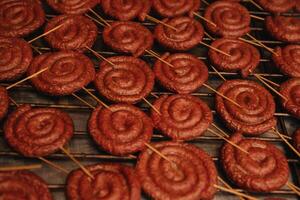 gebakken spiraal worstjes Aan een elektrisch barbecue bbq grillen. elektrisch bakplaat naar koken voedsel. Duitse braadworst varkensvlees worst. foto