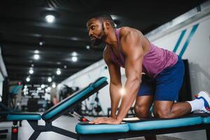 portret Afrikaanse Amerikaans bodybuilder Bij Sportschool intens intimiderend schittering uitdrukking overtuiging. foto