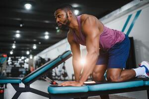 portret Afrikaanse Amerikaans bodybuilder Bij Sportschool intens intimiderend schittering uitdrukking overtuiging. foto