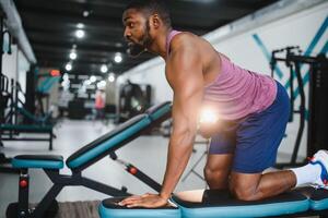 portret Afrikaanse Amerikaans bodybuilder Bij Sportschool intens intimiderend schittering uitdrukking overtuiging. foto