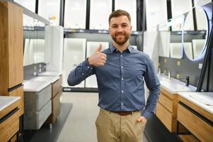 Mens kiezen nieuw badkamer meubilair Bij de loodgieter winkel met veel van sanitair goederen foto