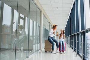 mam met haar dochter Bij luchthaven terminal met koffers aan het eten snel voedsel foto