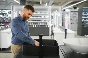 Mens kiezen badkamer wastafel en gereedschap voor zijn huis foto