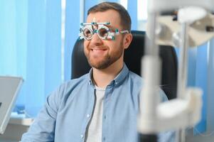 knap jong Mens is controle de oog visie in modern oogheelkunde kliniek. geduldig in oogheelkunde kliniek foto