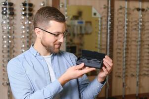 jong Mens kiezen bril Bij optiek winkel foto