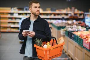 Mens boodschappen doen in een supermarkt foto