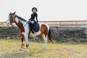 gelukkig modieus jong vrouw poseren met een paard Aan de strand foto