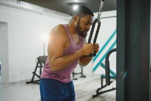 gewicht opleiding Afrikaanse aan het doen bodybuilding in Sportschool. foto