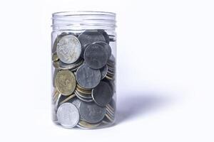 munten in glas pot geïsoleerd Aan wit achtergrond met kopiëren ruimte. besparing geld concept. foto