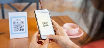 vrouw gebruik smartphone naar scannen qr code naar betalen in cafe restaurant met een digitaal betaling zonder contant geld. Kiezen menu en bestellen accumuleren korting. e portemonnee, technologie, betalen online, credit kaart, bank app. foto