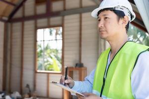 inspecteur of ingenieur is inspecteren bouw en kwaliteit zekerheid nieuw huis gebruik makend van een controlelijst. ingenieurs of architecten of contactor werk naar bouwen de huis voordat overhandigen het over- naar de huiseigenaar foto