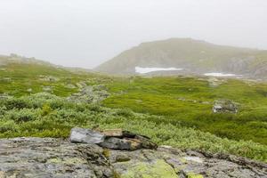mist, wolken, rotsen en kliffen op de berg veslehodn veslehorn, noorwegen. foto