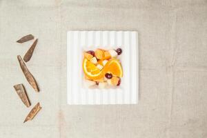 zoet gemengd fruit oranje, appel, bosbes geserveerd in een schotel geïsoleerd Aan tafel top visie van Indisch voedsel foto