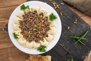 rundvlees hummus met pijnboom noten geserveerd in schotel geïsoleerd Aan tafel kant visie van Arabisch voedsel foto