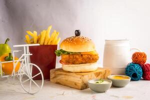 vis hamburger met Patat tomaat, en groen chili geïsoleerd Aan houten bord kant visie van Amerikaans snel voedsel foto