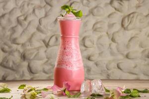 Arabisch stijl vers roos melk sappen geserveerd in pot geïsoleerd Aan achtergrond top visie drinken foto
