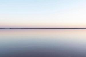 rustig minimalistische landschap, glad oppervlakte van roze zout meer foto
