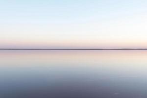 rustig minimalistische landschap, glad oppervlakte van roze zout meer foto