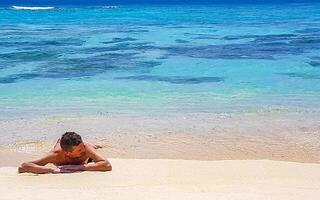 Mens aan het liegen Aan strand zand en water Aan tropisch strand Maldiven. foto