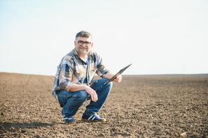 een boer cheques kwaliteit van bodem voordat zaaien. foto