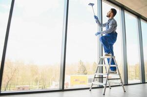 arbeider schoonmaak ramen onderhoud Aan hoog stijgen gebouw foto