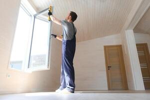 de arbeider installeren en controle venster in de huis. concept van nieuw modulair huizen. foto