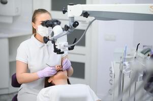 professioneel tandarts examen geduldig met microscoop Bij de kantoor foto