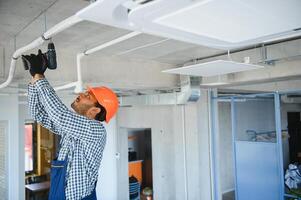 professioneel technicus onderhouden modern lucht conditioner binnenshuis. ruimte voor tekst foto