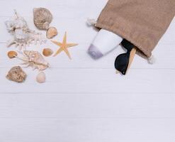 strand accessoires. handdoek, slippers, zeester, boot en zonnebril Aan houten achtergrond. top visie met kopiëren ruimte. zonnig afgezwakt foto
