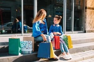 uitverkoop, consumentisme en mensen concept - gelukkig jong Dames haar dauther met boodschappen doen Tassen wandelen stad straat foto