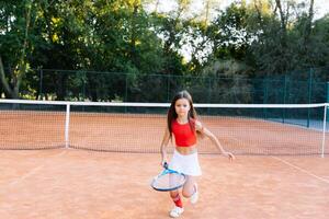 schattig weinig meisje spelen badminton buitenshuis Aan warm en zonnig zomer dag foto