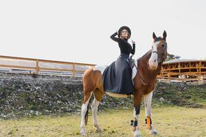 gelukkig modieus jong vrouw poseren met een paard Aan de strand foto