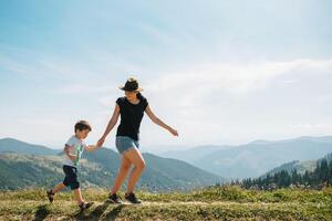 jong mam met baby jongen reizend. moeder Aan wandelen avontuur met kind, familie reis in bergen. nationaal park. wandeltocht met kinderen. actief zomer vakantie. foto