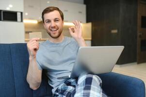 lachende man tijdens online winkelen thuis foto
