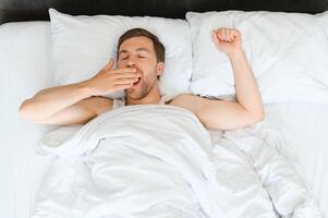 schattig jong Mens slapen Aan bed foto