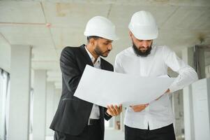 multi-etnisch bedrijf team. bouw concept. Indisch en Arabisch ingenieurs inspecteren de bouw. foto