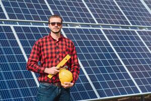 jong technicus installeren zonne- panelen Aan fabriek dak foto