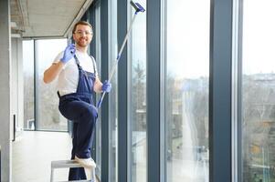 een werknemer van een professioneel schoonmaak onderhoud wast de glas van de ramen van de gebouw. vitrine schoonmaak voor winkels en ondernemingen. foto