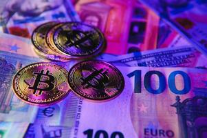 dichtbij omhoog hoop van gouden bitcoin fysiek munten Aan top van euro, dollar bankbiljetten achtergrond, hoog hoek visie, selectief focus foto