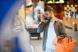 knap Mens boodschappen doen in een supermarkt foto