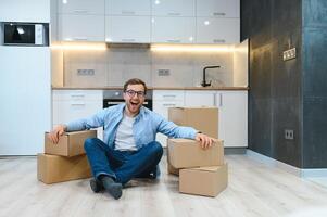 in beweging, mensen en echt landgoed concept - gelukkig glimlachen Mens met dozen Bij nieuw huis foto