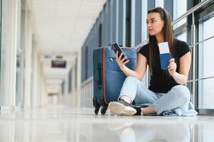 toerisme, vakantie, vakantie, kinderjaren en vervoer concept - glimlachen weinig meisje met reizen zak over- luchthaven achtergrond foto