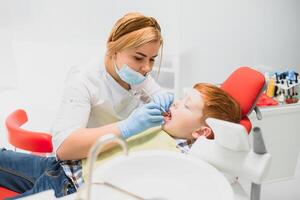 jongen tevreden met de onderhoud in de tandheelkundig kantoor. concept van pediatrisch tandheelkundig behandeling foto