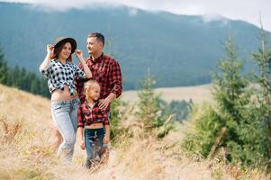 jong familie met kind resting Aan een berg. vakantie in de nationaal park foto