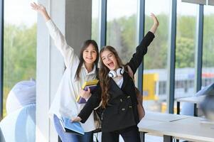 glimlachen meisjes in hoog school- hal. twee vrouw college studenten pratend na lezing. foto